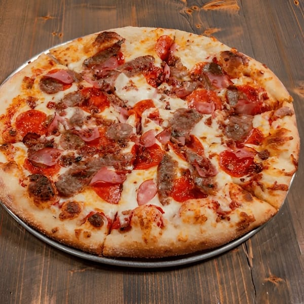 A whole meat lover's pizza with pepperoni, sausage, and ham on a wooden table.